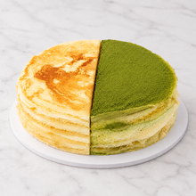Load image into Gallery viewer, Millie crepe cake, half vanilla and half matcha, on white marble