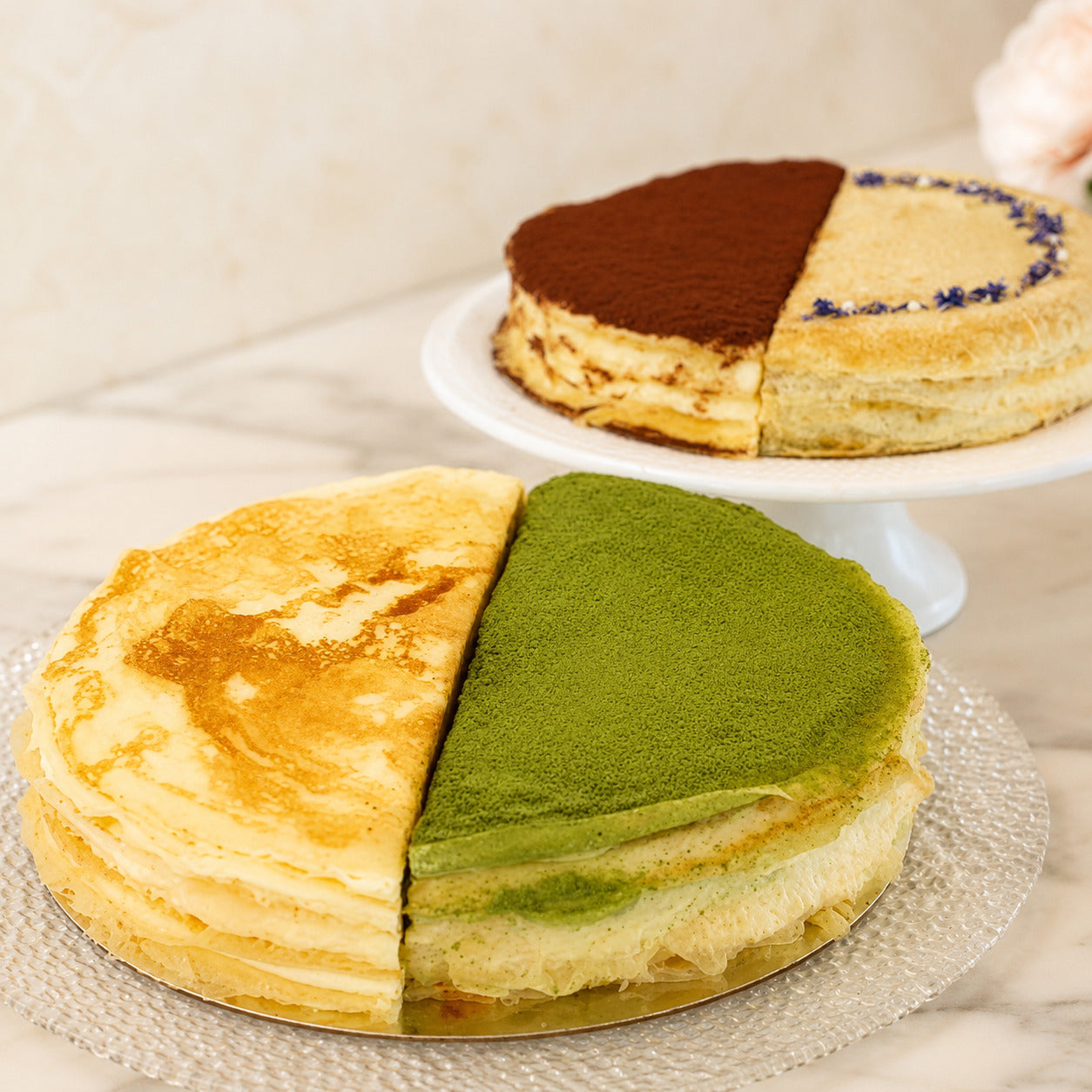 Whole crepe cake split into two flavours, one half matcha and one half vanilla