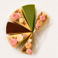 Load image into Gallery viewer, Assorted slices of cake with decorative flowers on a white background
