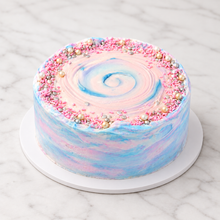 Load image into Gallery viewer, Gender Reveal crepe cake in pink and blue whipped cream with sprinkles and pearls on white marble
