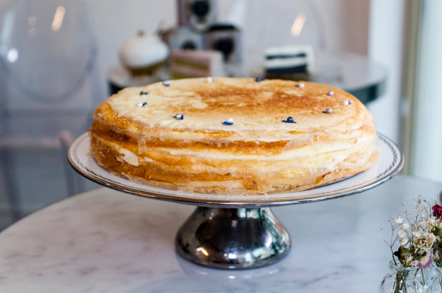 Whole mille crepe cake on a silver cake stand